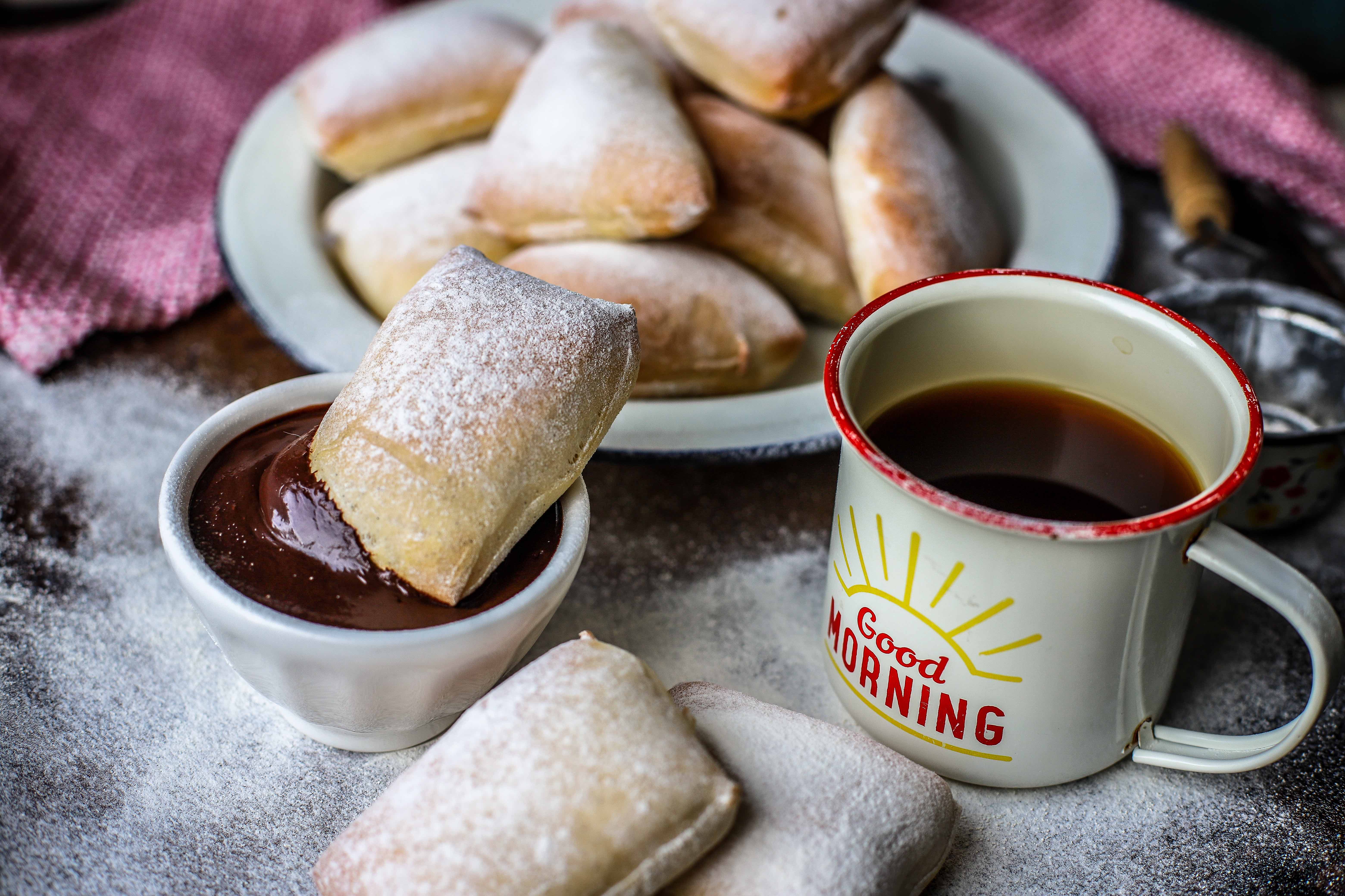 Baked version of New Orleans iconic doughnut, the beignet. Square pillows of soft yeast dough are baked and showered in confectioners' sugar then dipped into a thick, homemade hot chocolate sauce. A traditional Mardi Gras - Fat Tuesday - treat.