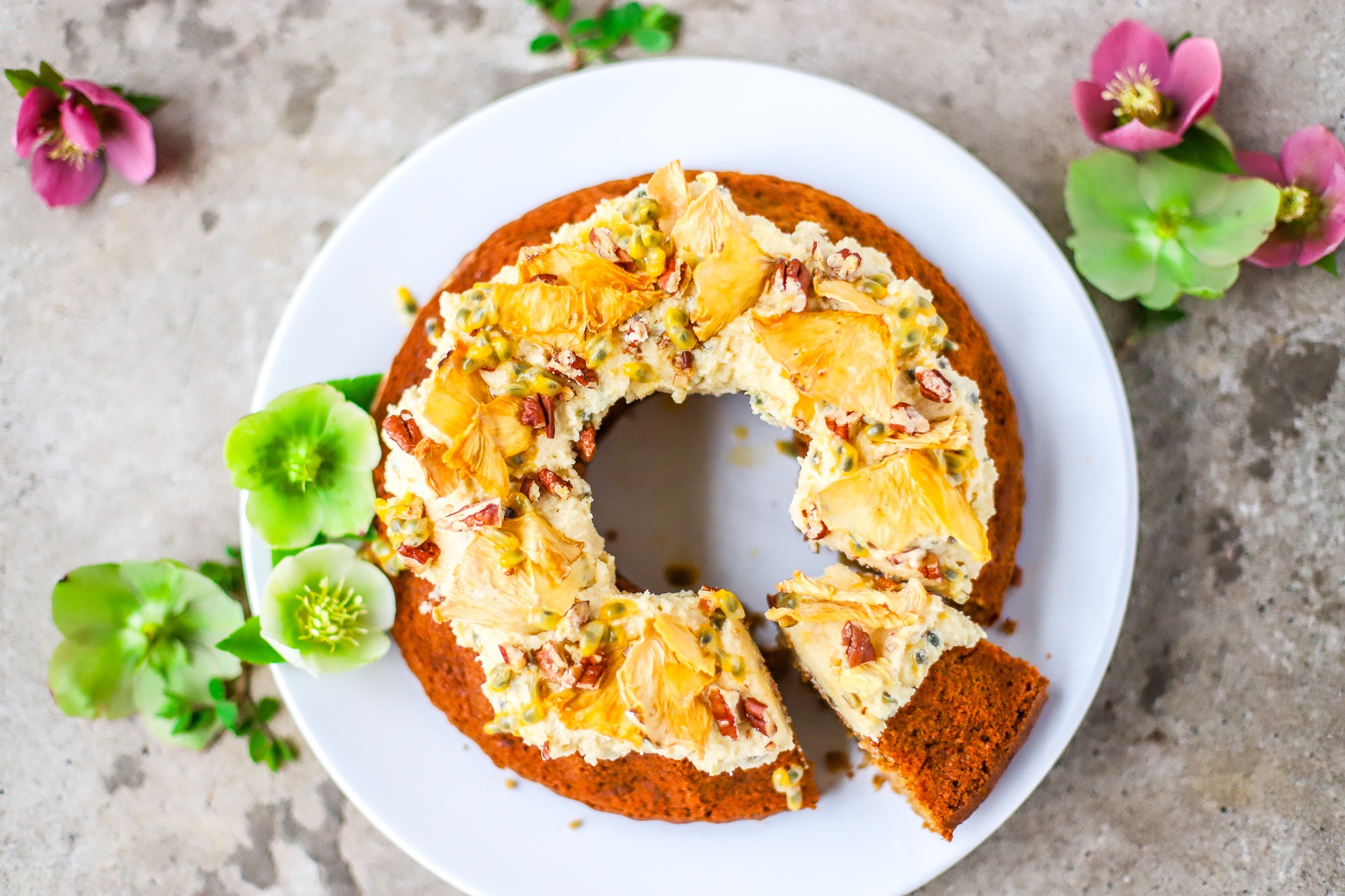 overhead view of decorated hummingbird cake with one slice cut and on white plate with green flowers