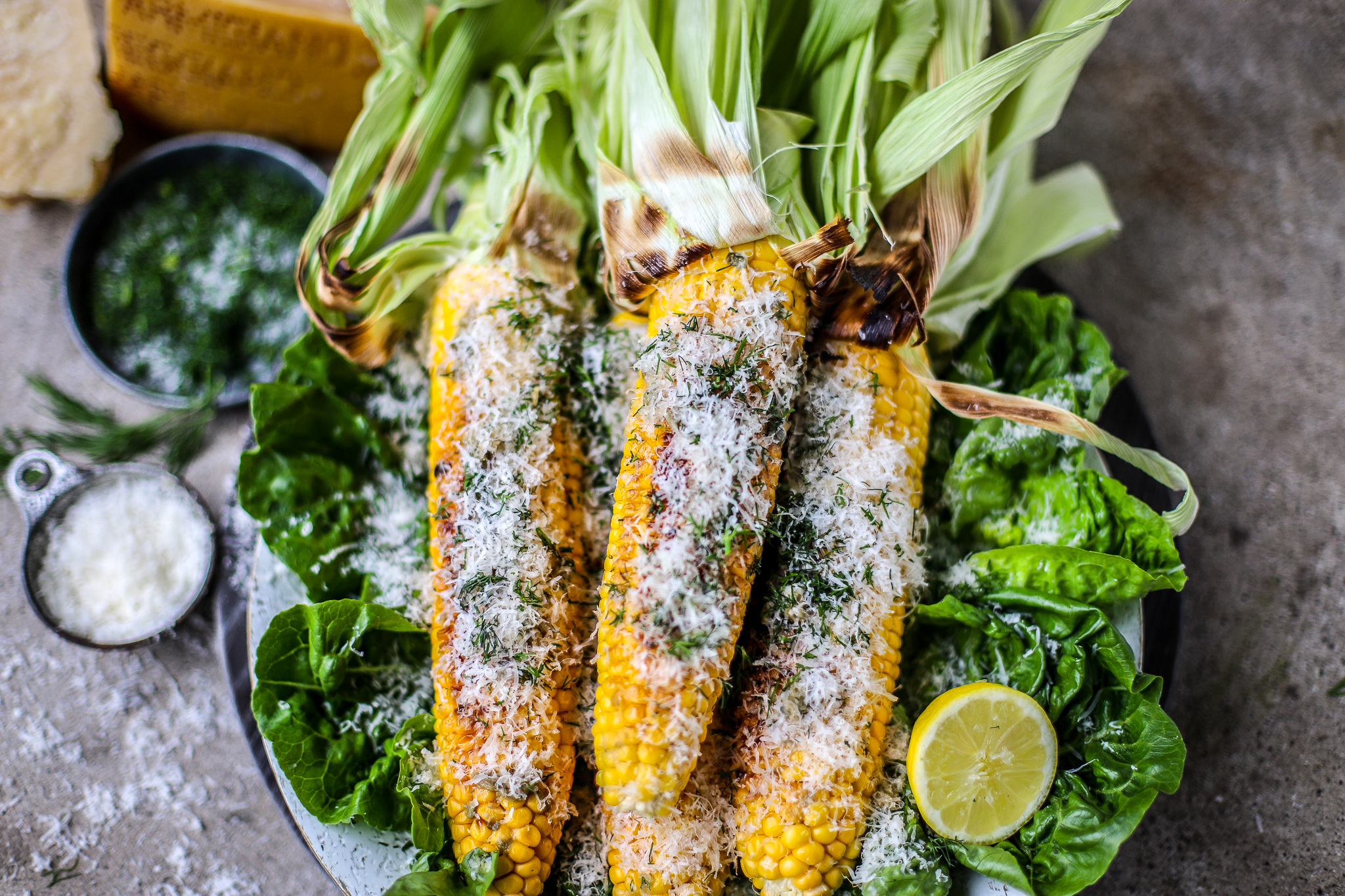 grilled corn with parmesan and dill, on concrete background